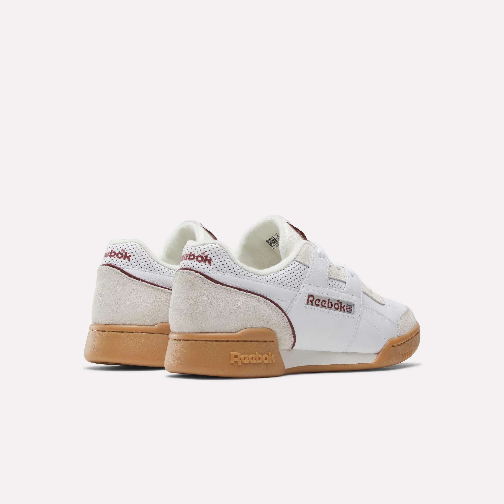 A pair of Reebok Workout Plus Shoes in white, featuring gum soles, suede heel accents, and red details—evoking classic '80s style—displayed from the rear on a plain white background.