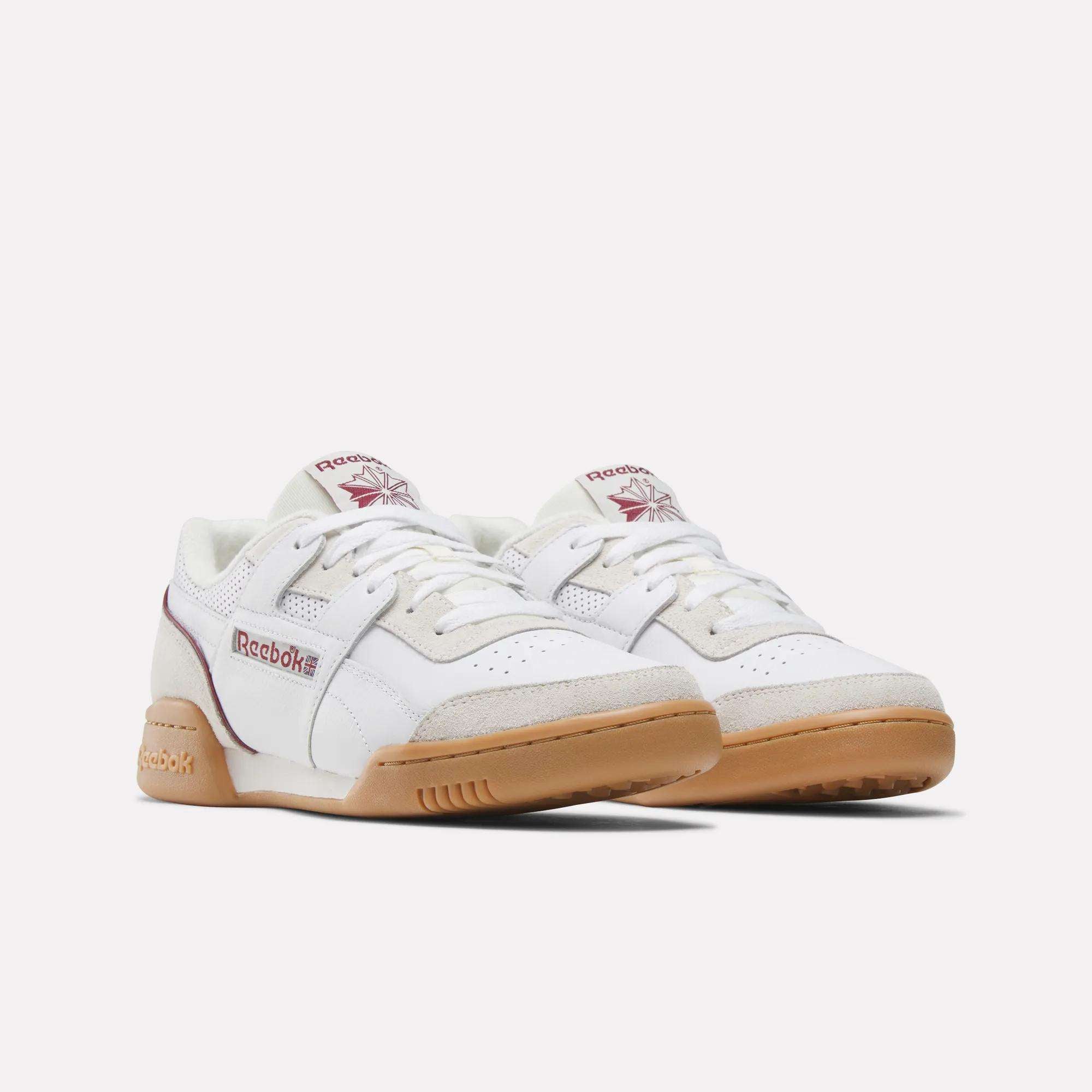 The Reebok Workout Plus Shoes feature white uppers, gum rubber soles, maroon accents, and prominent Reebok branding on the side and tongue, capturing iconic '80s fitness style against a plain white background.