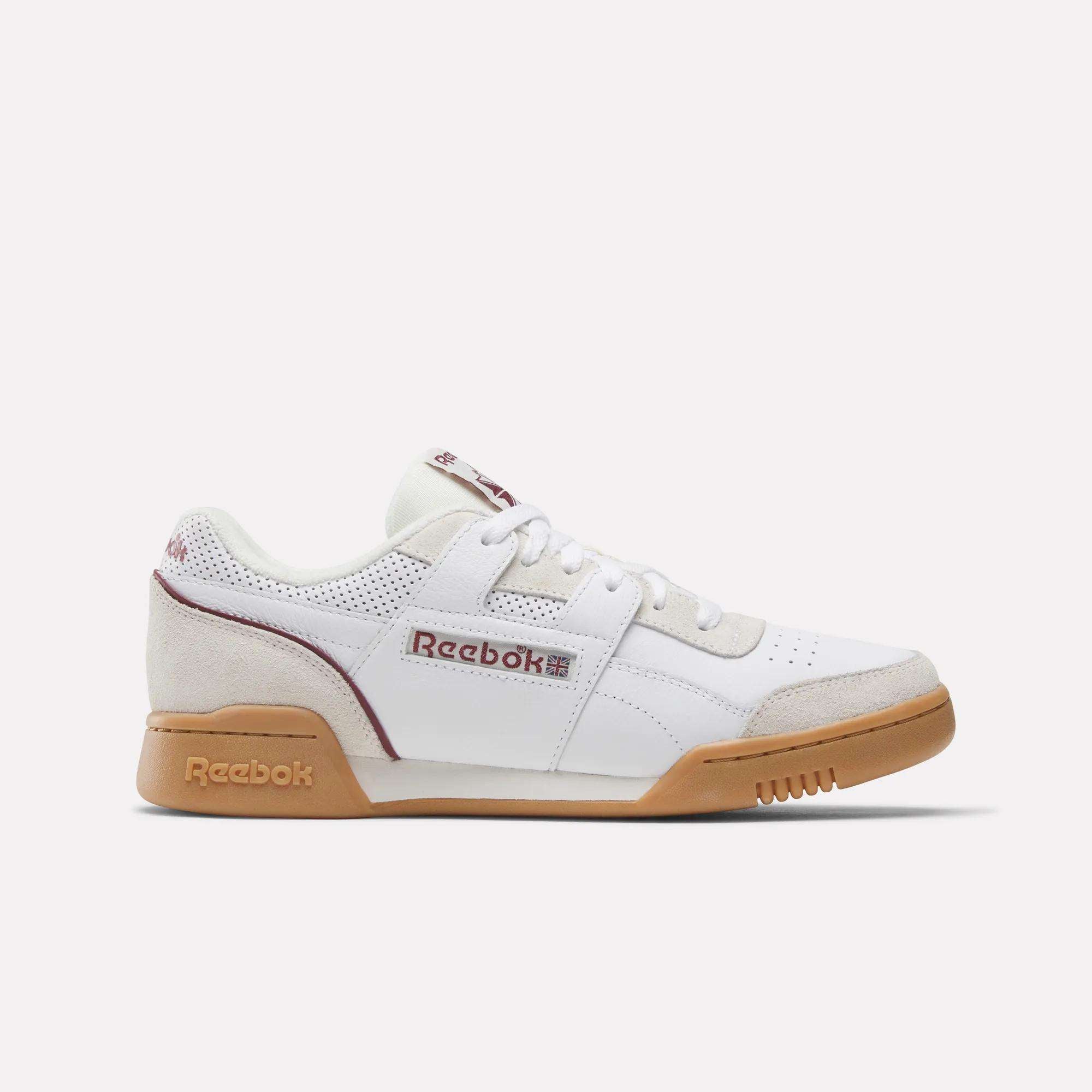 The Reebok Workout Plus Shoes feature a white upper with maroon accents, beige suede details, and a brown gum sole—shown in side profile on a plain, light background for a classic retro look.