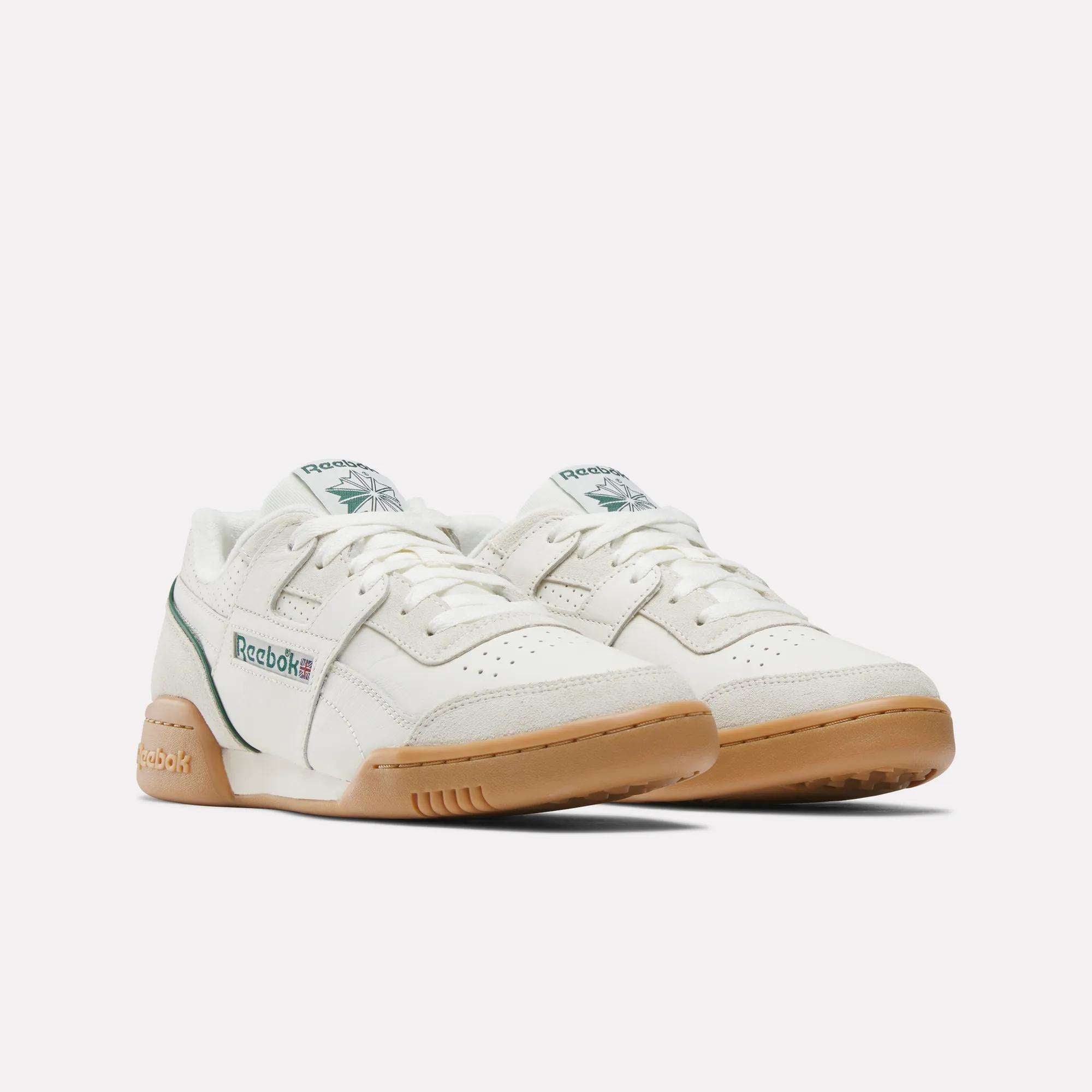 The Reebok Workout Plus Shoes are white sneakers with green accents and gum rubber soles, showcasing classic '80s fitness style. They feature the Reebok logo on the side and tongue and are shown against a plain white background.