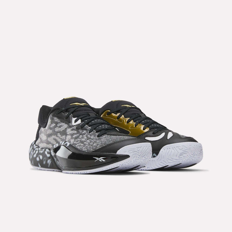 The Reebok Engine A 26 Basketball Shoes feature a black, white, and gold patterned design, ERS+ System cushioning, white textured soles, and black and gold accents, shown against a plain light background.