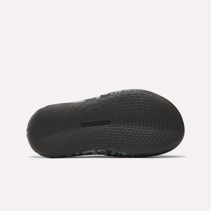 Close-up of the sole on Reebok DMX Recovery Mules, a black athletic shoe with DMX cushioning and wavy tread for excellent grip—perfect as recovery footwear after intense workouts.