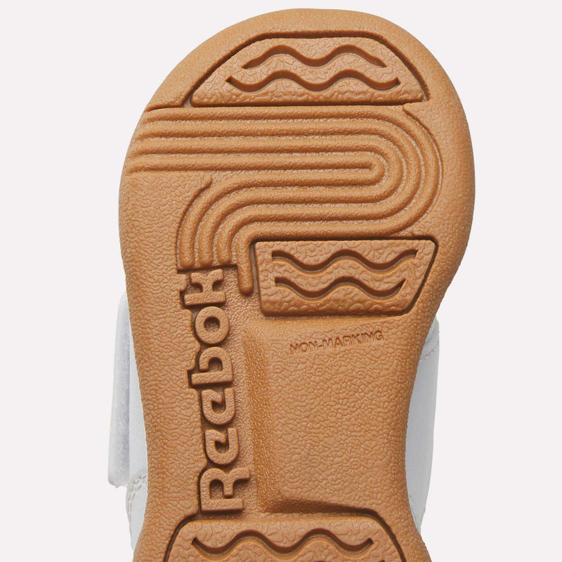 Close-up of the tan rubber sole on Reebok Kids' Workout Plus Shoes for babies and toddlers, featuring textured patterns, the Reebok logo, and "NON-MARKING" embossed on the bottom—perfect for little ones.