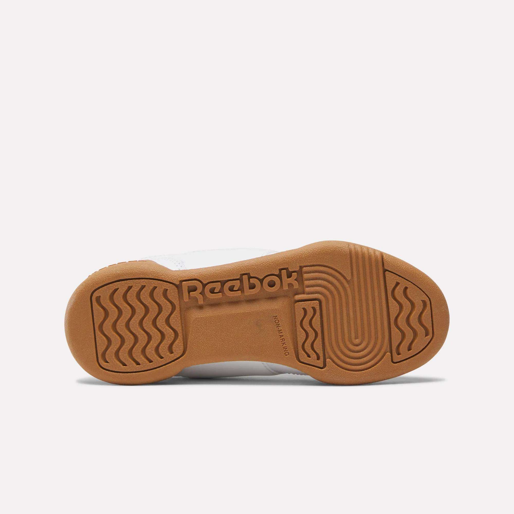 A brown rubber outsole on the Reebok Workout Plus Shoes for little kids is shown from the bottom, displaying the Reebok logo and textured grip patterns—ideal traction for active days.
