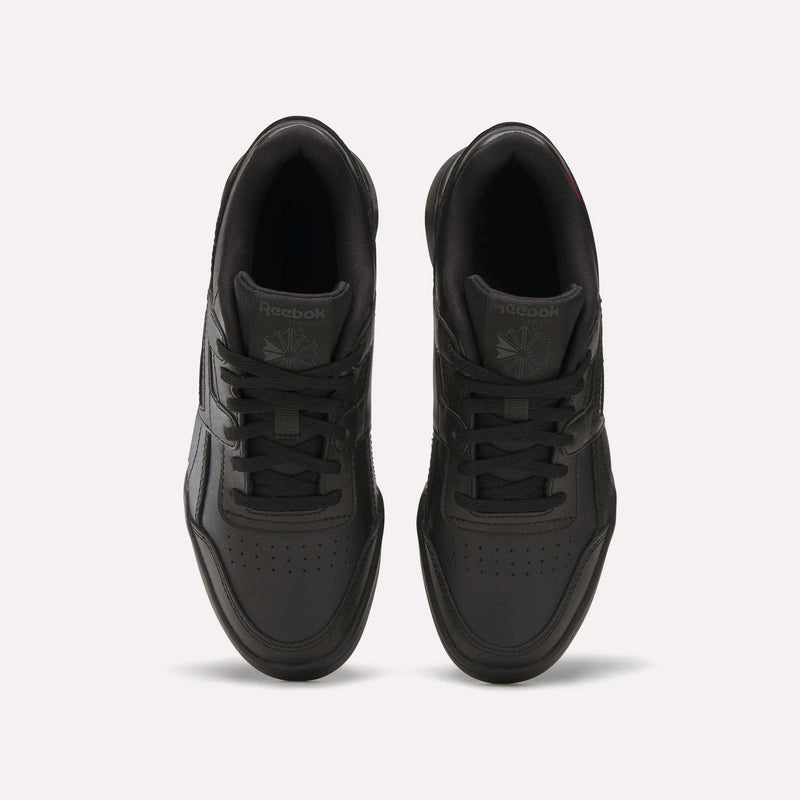 Top view of a pair of black Reebok Workout Plus Shoes for big kids with laces, displayed side by side on a white background. The Reebok logo appears on the tongue of each sneaker.