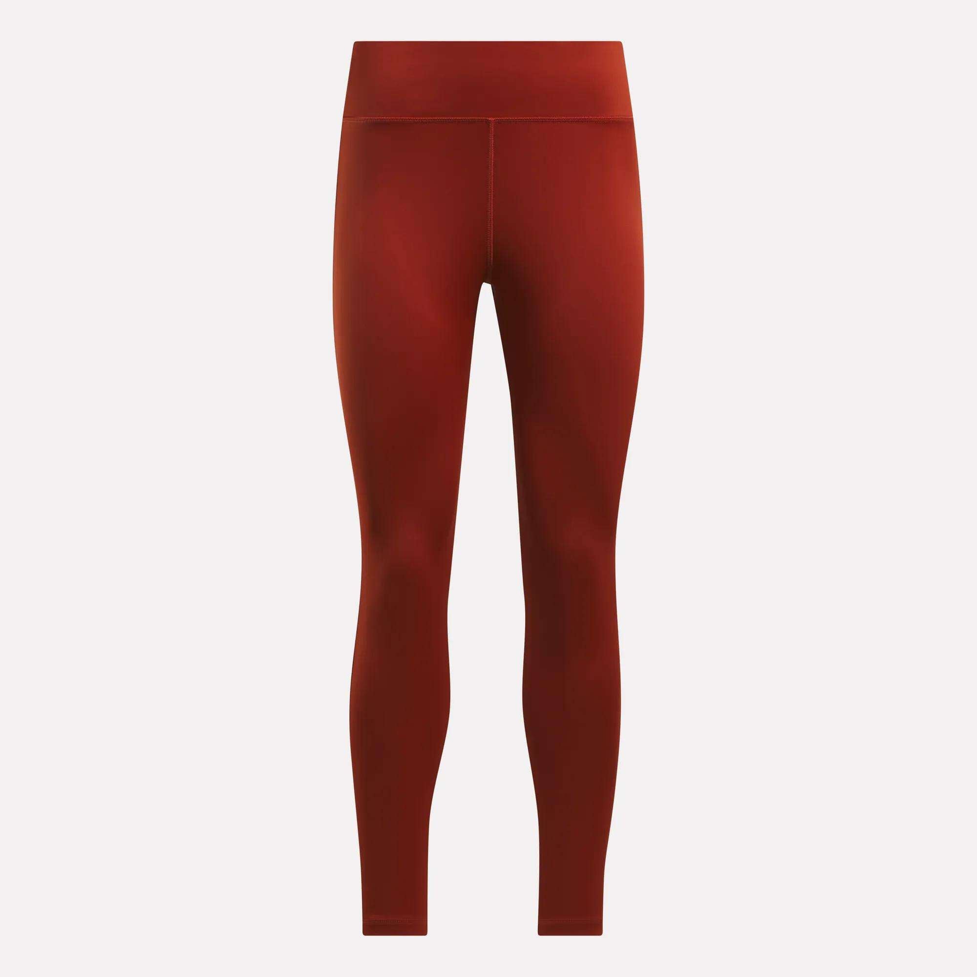 Reebok Women's Lux High-Rise Tights in red, shown full-length on a light background. These high-waisted training tights feature a smooth, fitted look with advanced RBK-DRY fabric and no visible patterns or logos.