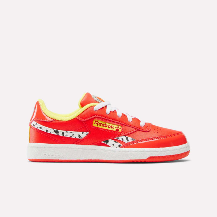 The Reebok x Paw Patrol Club C Revenge Shoes for little kids feature a bright red design with white laces, yellow accents, a black-and-white spotted side pattern, retro tennis style, yellow lining, and a comfy white sole.