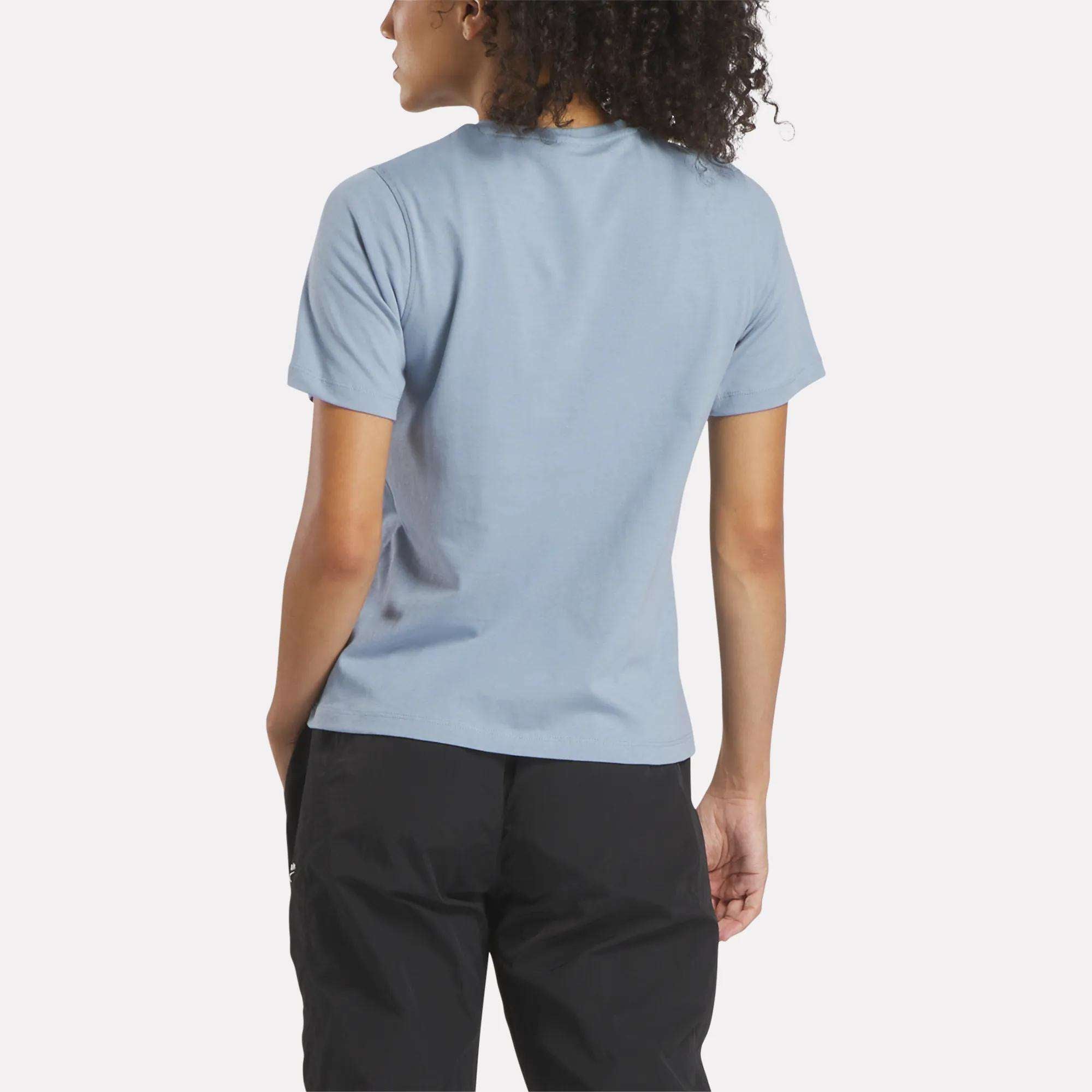 A woman wearing a blue Reebok Women's Big Logo Crewneck Short Sleeve Tee.