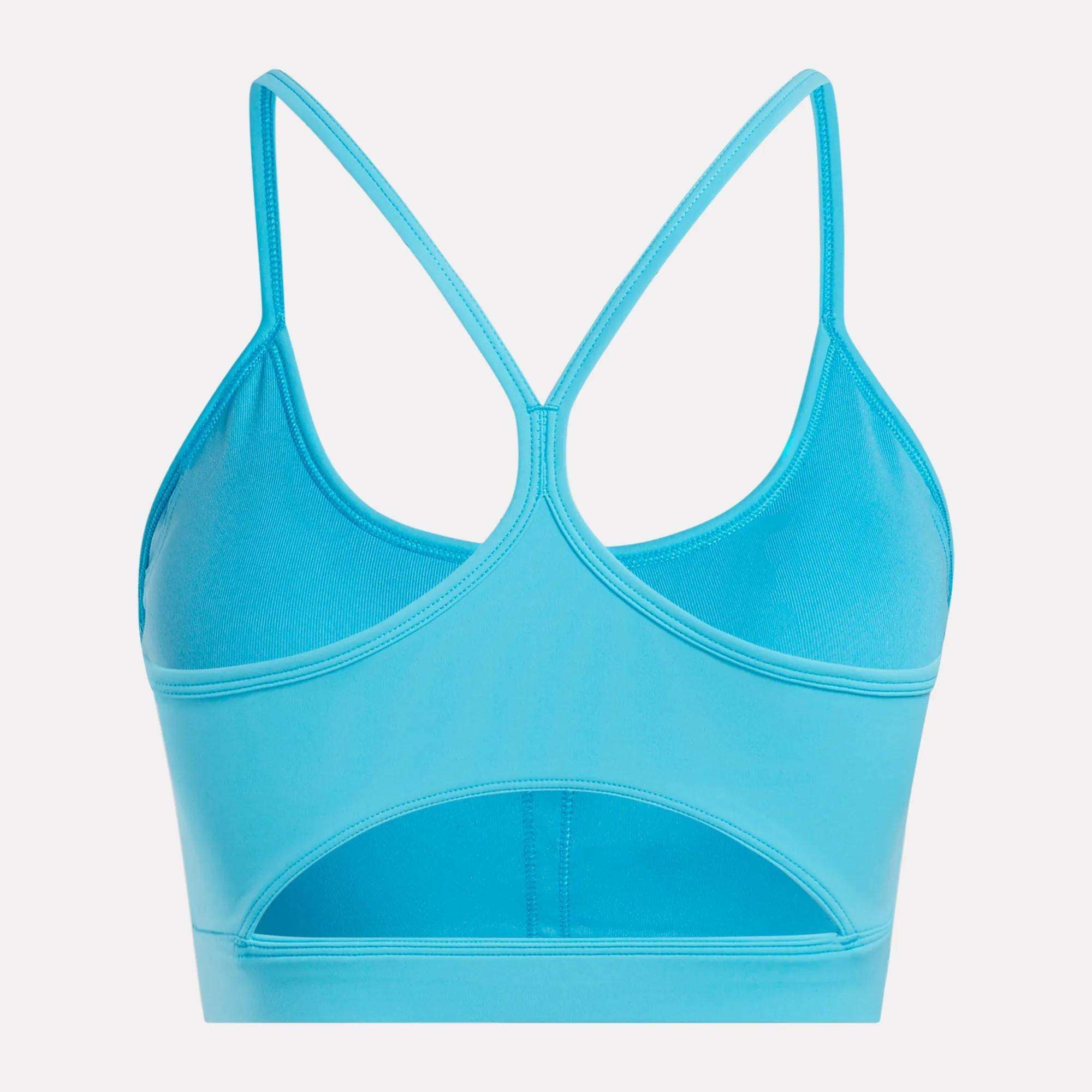 The Reebok Women's Core Strappy Bra - Medium Support features thin crisscross back straps, a wide lower-back cutout, and smooth quick-drying fabric—perfect for medium-impact workouts.