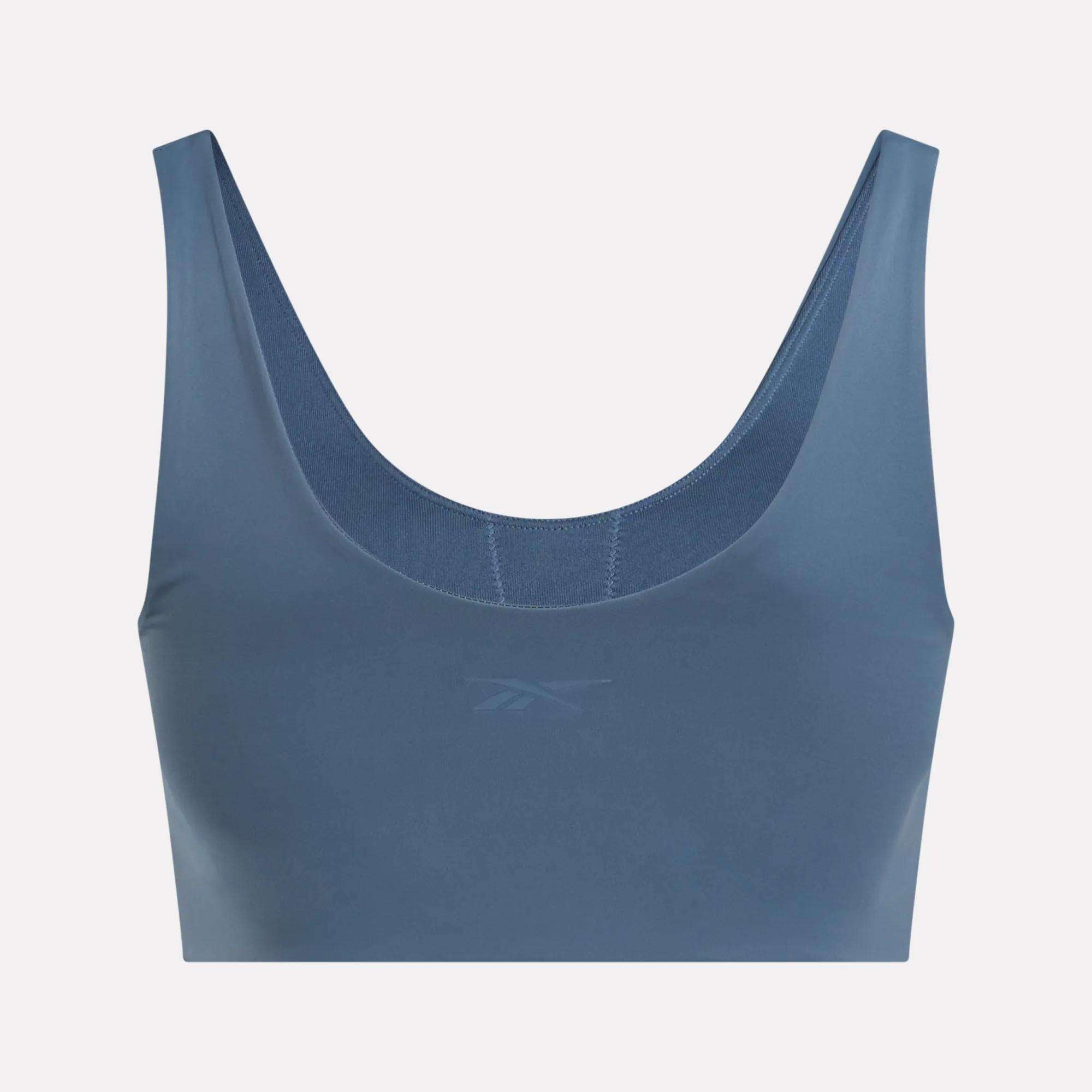 The Reebok Women's Yoga V-Neck Bra features a scoop neckline, wide straps, and a subtle front logo. Its seamless design provides medium-impact support—ideal for studio workouts or casual wear.