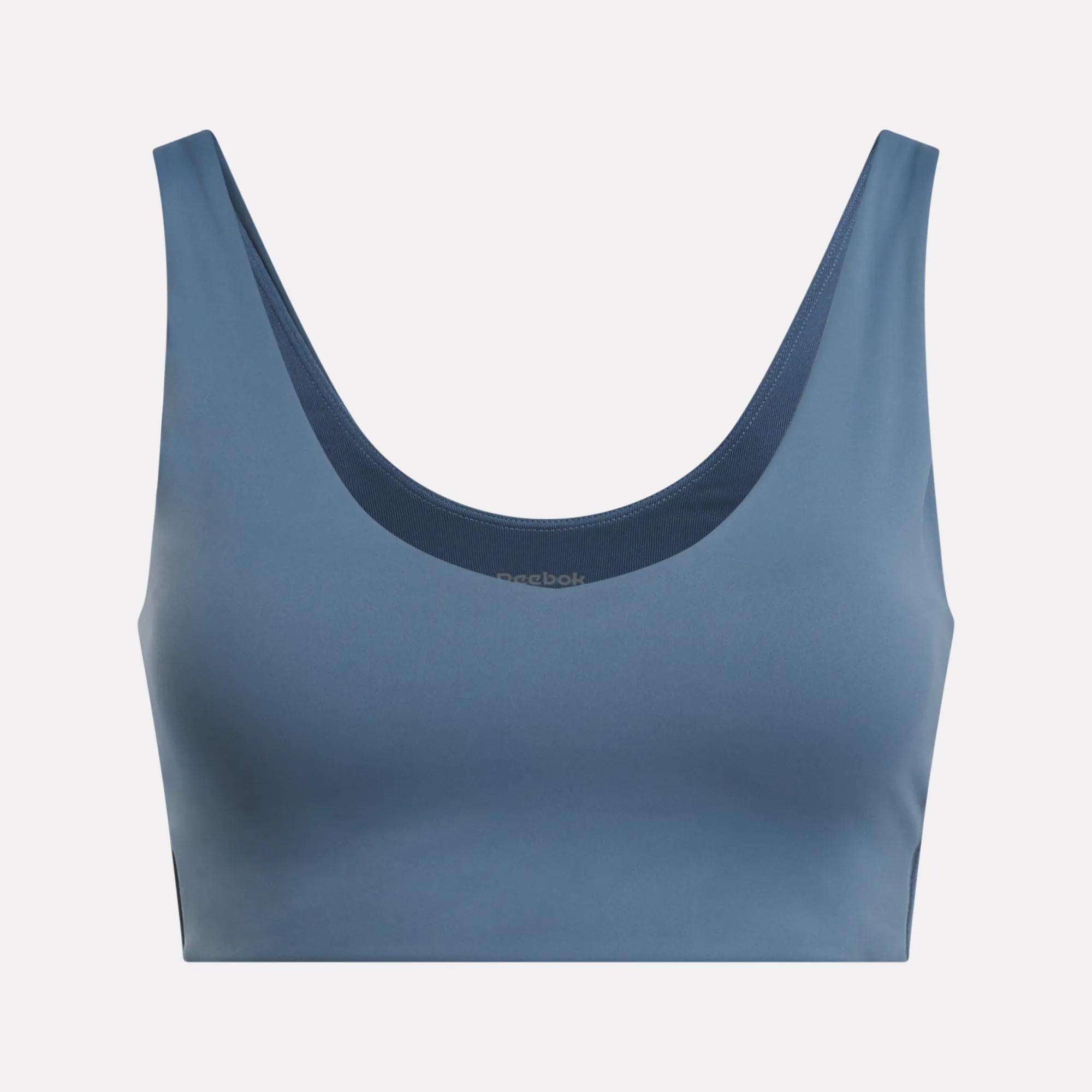 The Reebok Women's Yoga V-Neck Bra in blue features a seamless design and supportive fit, ideal for studio workouts. Shown on a light background.