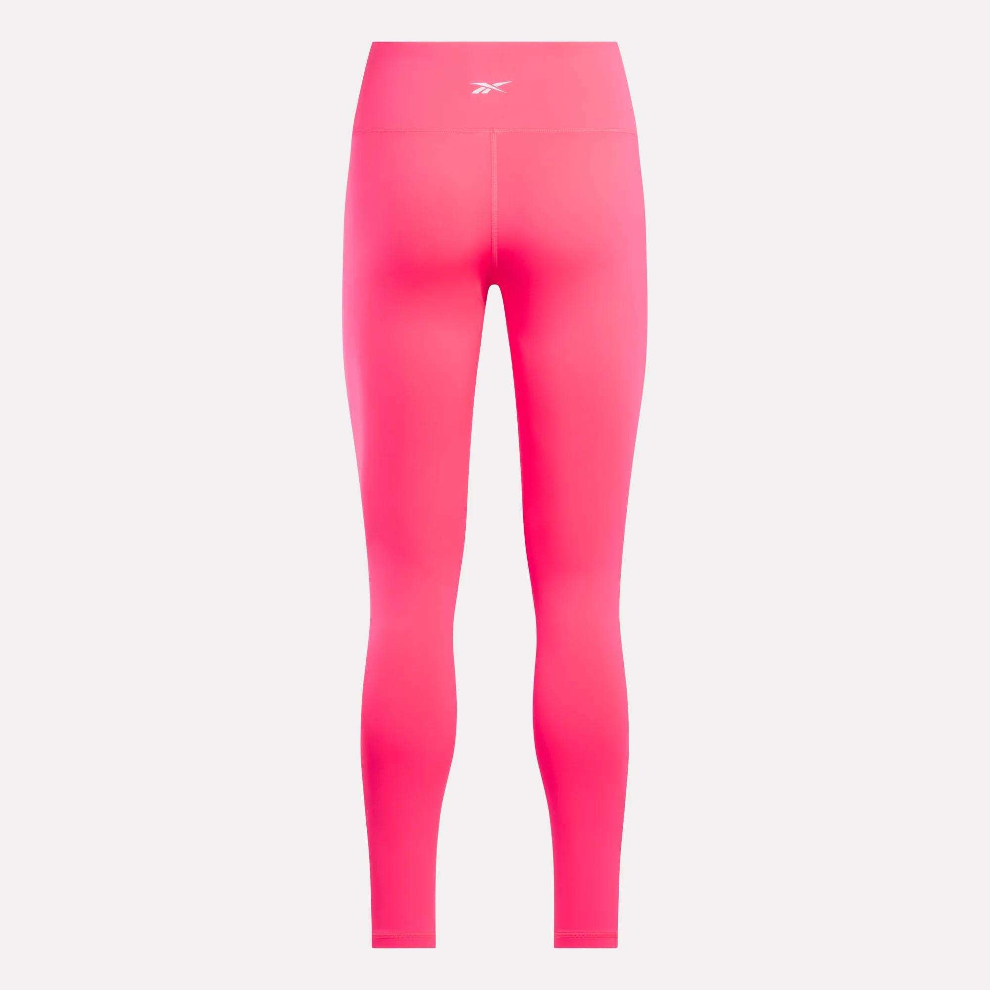 Reebok Women's Core High-Rise Leggings in bright pink, made with RBK-DRY fabric and featuring a small white Reebok logo on the waistband, displayed from the back against a plain white background.