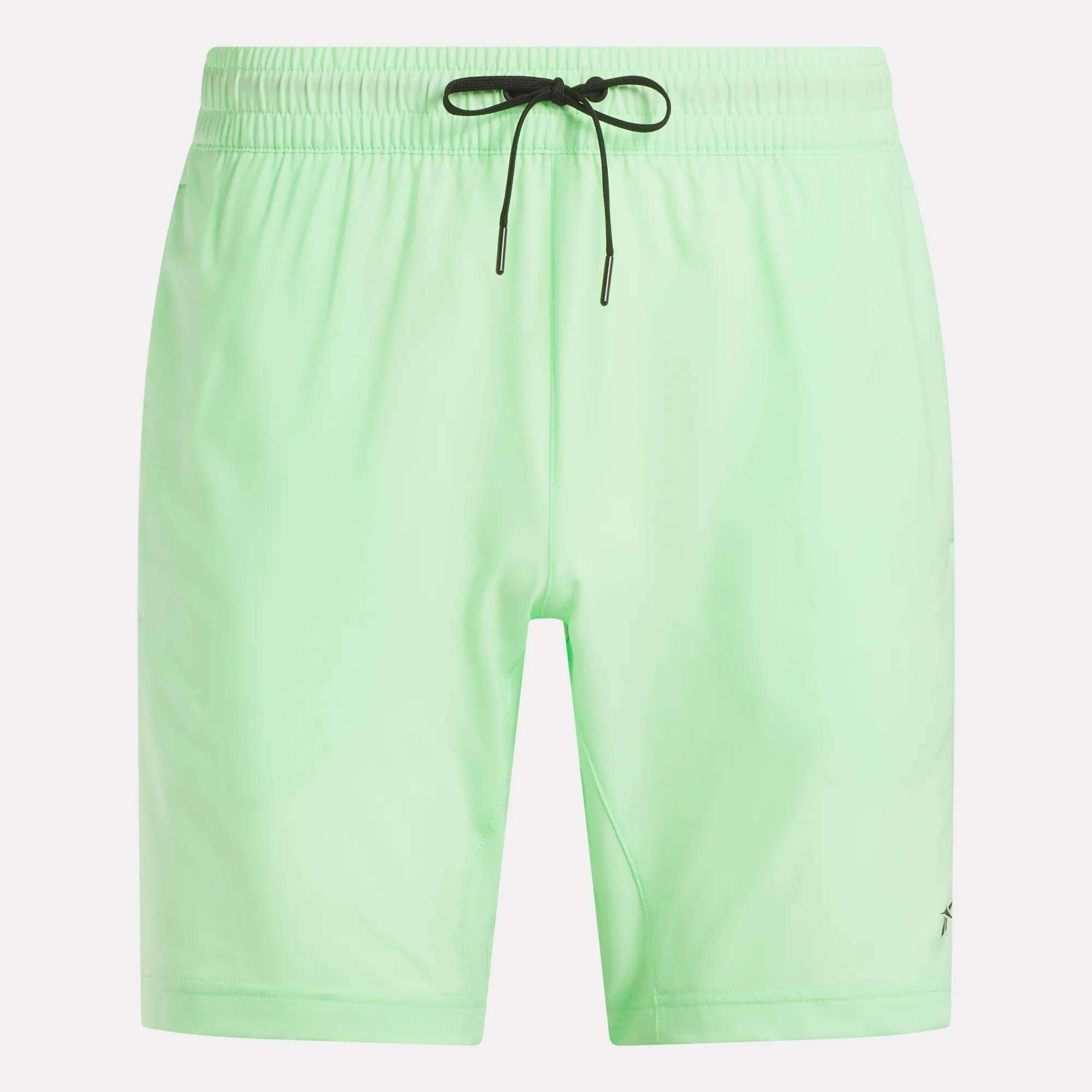 The Reebok Men's Workout Ready Woven Shorts in light green have an elastic waistband with a black drawstring. These sweat-wicking, solid-color shorts offer comfort and style for any activity, shown here against a white background.
