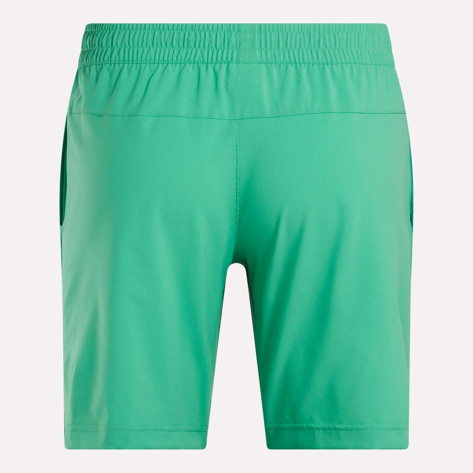 Men's Workout Ready Woven Shorts by Reebok, shown from the back in bright green with an elastic waistband, side pockets, and lightweight sweat-wicking fabric against a plain white background.