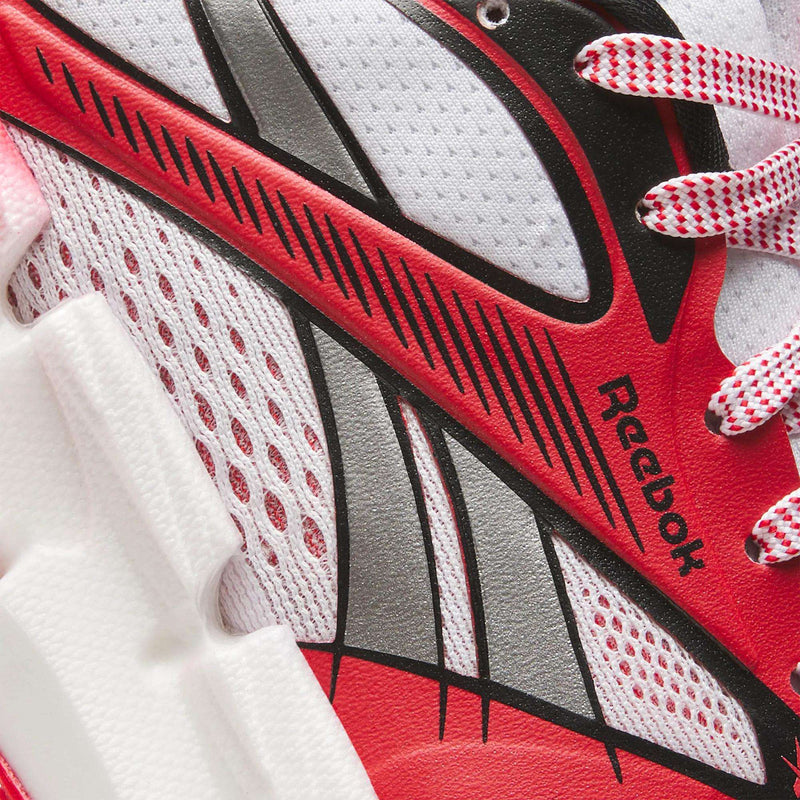 Close-up of Reebok Men's FloatZig 2 AHA Running Shoes in red, white, and black, featuring mesh texture, white laces with red specks, signature side logo, and energy-returning cushioning for enhanced comfort.