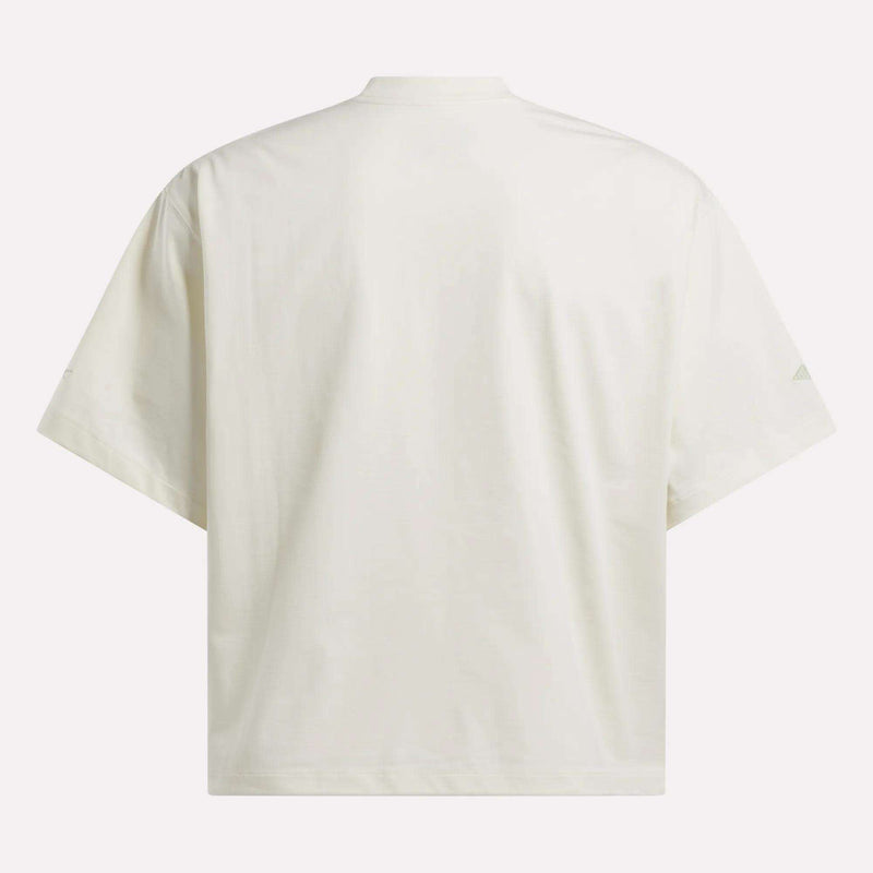 The Reebok x CHUKWU Tee is shown from the back, featuring an oversized fit, crew neckline, and no visible logos or designs. Subtle mint tones give this minimalist Reebok piece a fresh look.