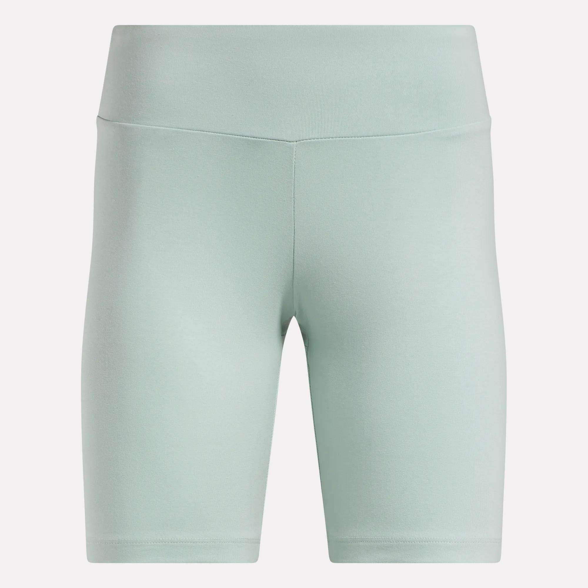 Reebok Women's Small Logo Cycle Shorts in light green feature a high-waist, smooth cotton finish, front seam detailing, and fitted knee-length stretchy design, shown against a plain white background.