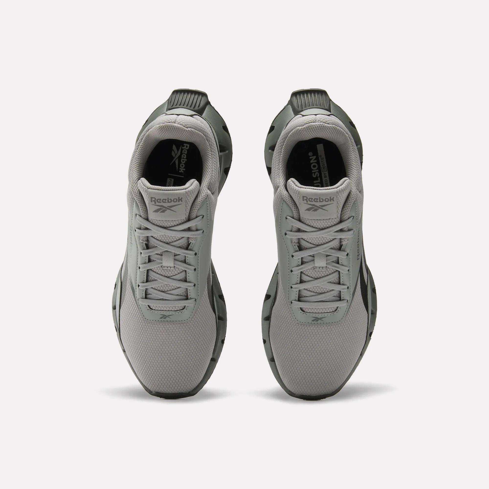 A pair of light gray Reebok Zig Dynamica STR Shoes viewed from above, featuring a mesh upper, lace-up fronts, black outsoles, plush EVA cushioning, and the Reebok logo on the tongue and insole.