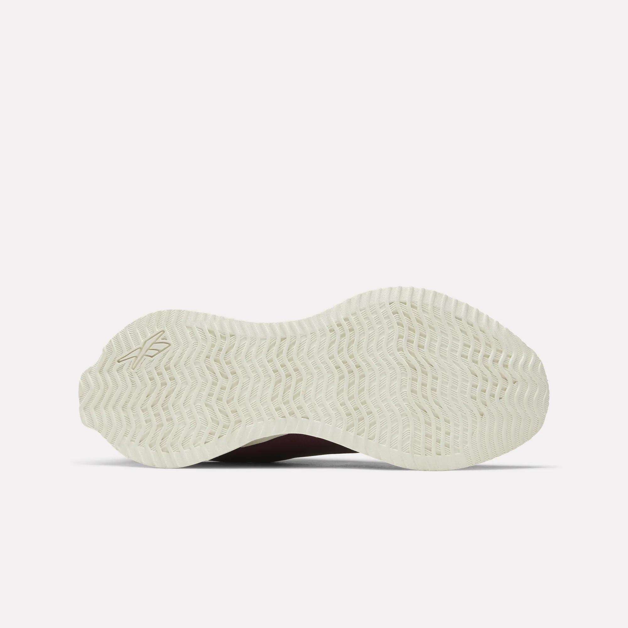 The image displays the white rubber outsole of the Reebok Women's Zig Dynamica STR Shoes, featuring a wavy herringbone tread pattern, photographed from below against a plain light background.