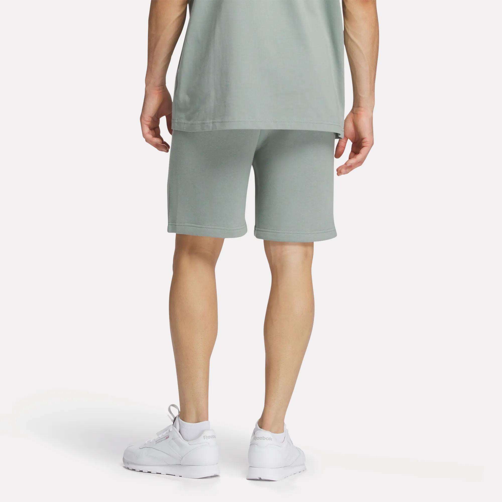 A man wearing Reebok Men's Crest Shorts and a t-shirt.