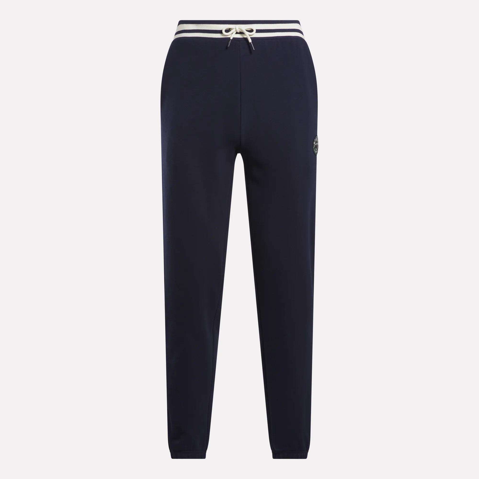 Men's Lawn Club French Terry Jogger Pants by Reebok in navy blue, featuring a white drawstring waist, white-striped waistband, and small circular logo on the left thigh, made from soft cotton-blend material. Displayed on a plain background.