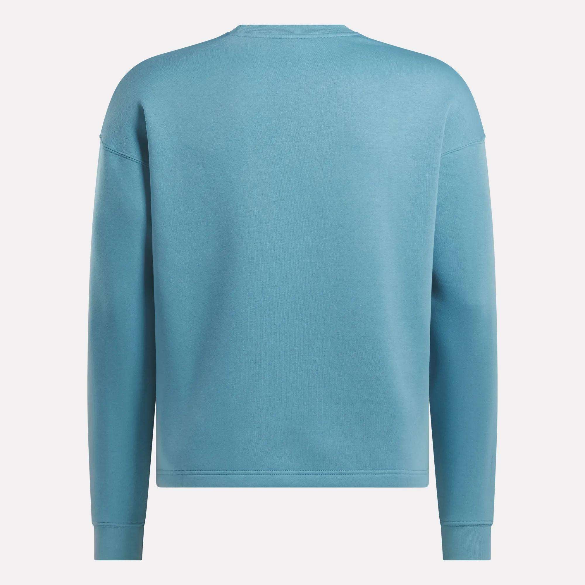 The Men's Wardrobe Essentials Sweatshirt by Reebok is a light blue, plain long-sleeve top crafted from soft cotton-blend fleece. Shown from the back on a white background, it features a relaxed fit with no logos or patterns.