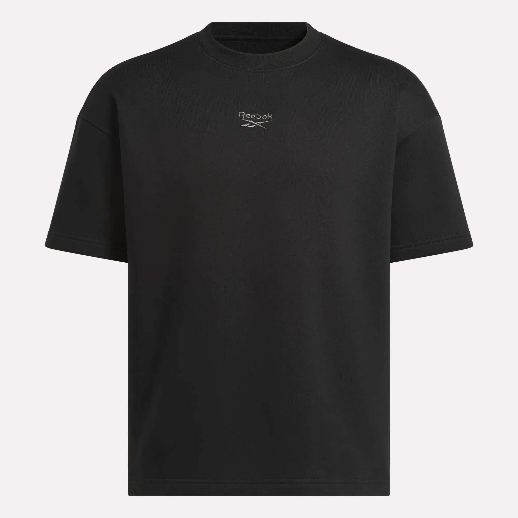 The Reebok Men's Wardrobe Essentials T-Shirt is a plain black crewneck with a small logo and centered text on the chest, offering a relaxed fit and classic style for everyday comfort.