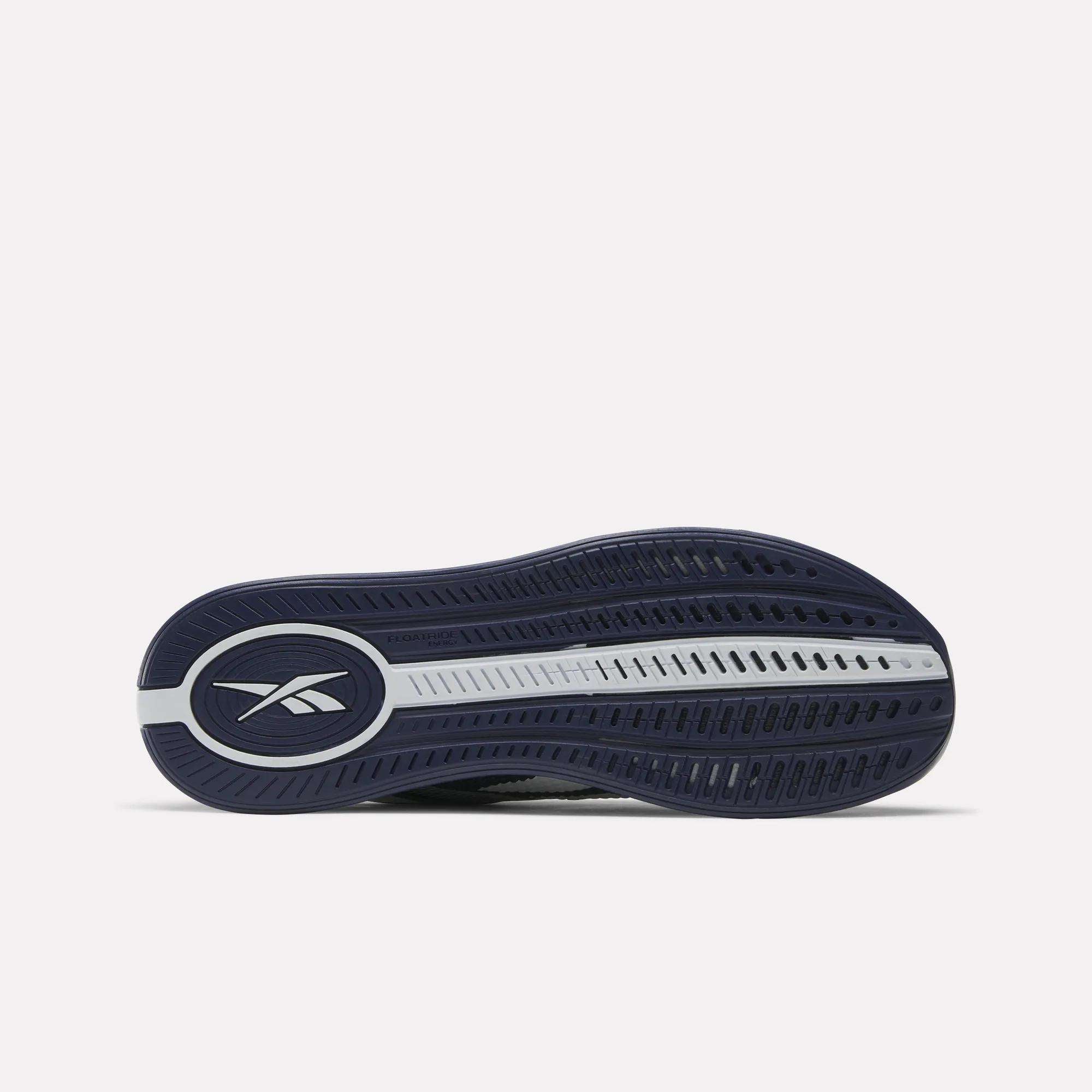 The image shows the navy blue and white rubber outsole of the Reebok Nano X4 Training Shoes, lying flat with the sole facing up. The Reebok logo appears on the left within an oval, highlighting its Flexweave design.