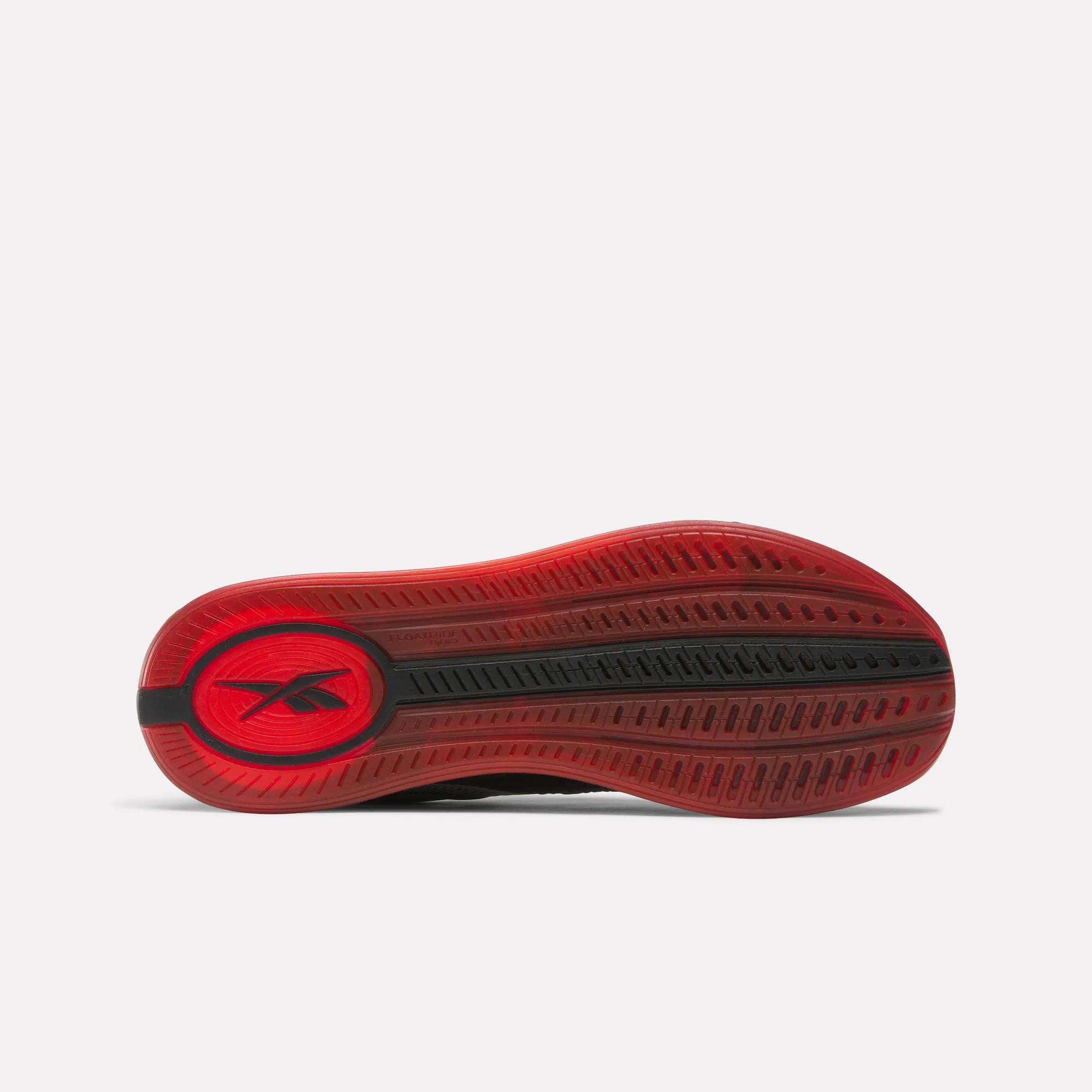 The image shows the red outsole of the Reebok Nano X4 Training Shoes with black tread patterns and a circular logo near the heel, viewed from below on a white background—ideal for gym enthusiasts.