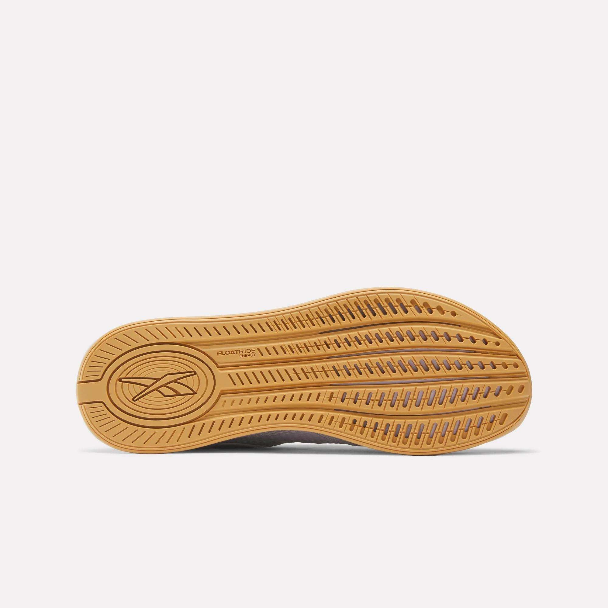 The image displays the tan sole of the Reebok Women's Nano X4 Training Shoes facing upward, showing a textured tread, Reebok logo, “FLOATRIDE,” and Floatride Energy Foam. The background is plain white.