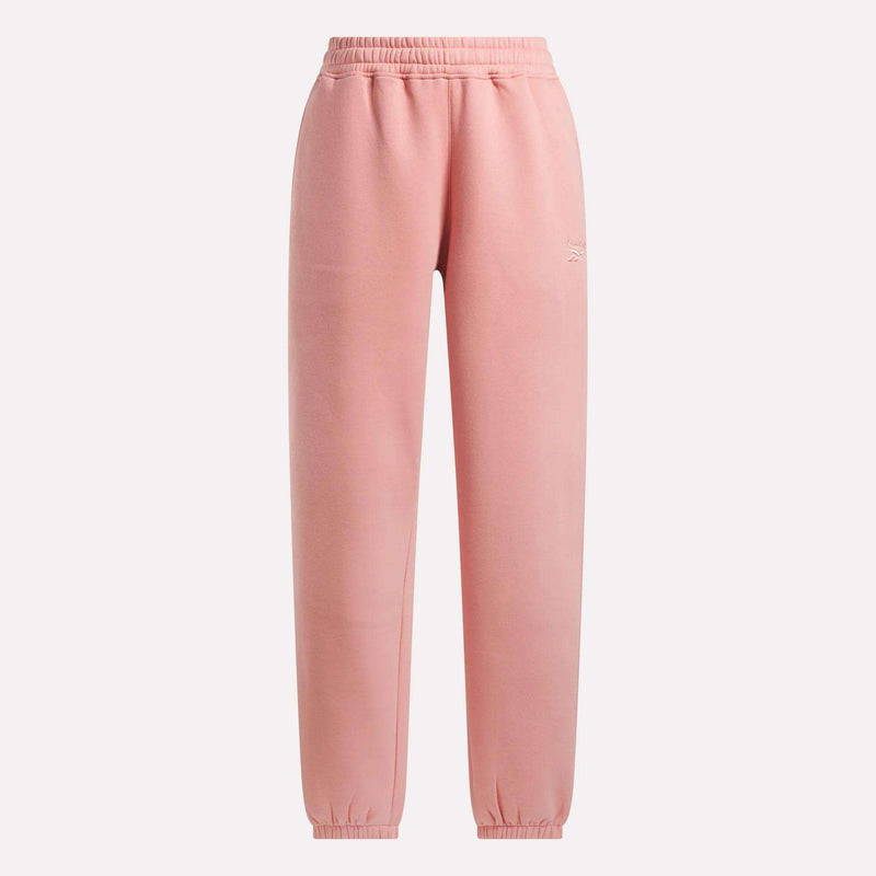 Reebok Women's Wardrobe Essentials Sweat Pants in soft pink, with an elastic waistband and ankle cuffs, shown on a plain white background.