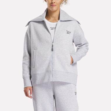 A woman wearing a grey Reebok Women's Wardrobe Essentials Retro Zip Top and soft fleece sweatpants.