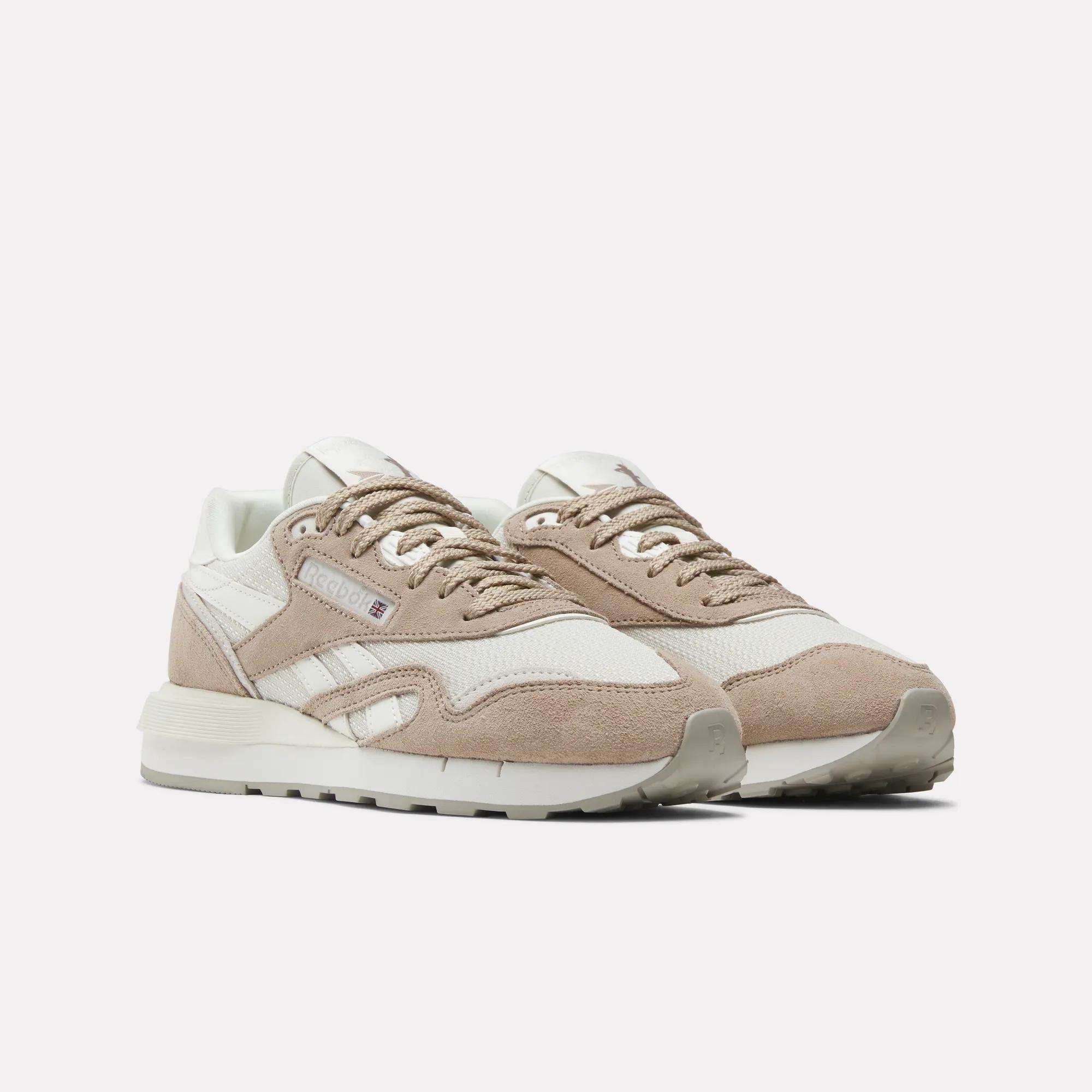 The Reebok Women's Classic Nylon 89 Shoes feature beige and white suede and mesh uppers, white midsoles, beige outsoles, and white laces for a retro look, shown against a plain white background.
