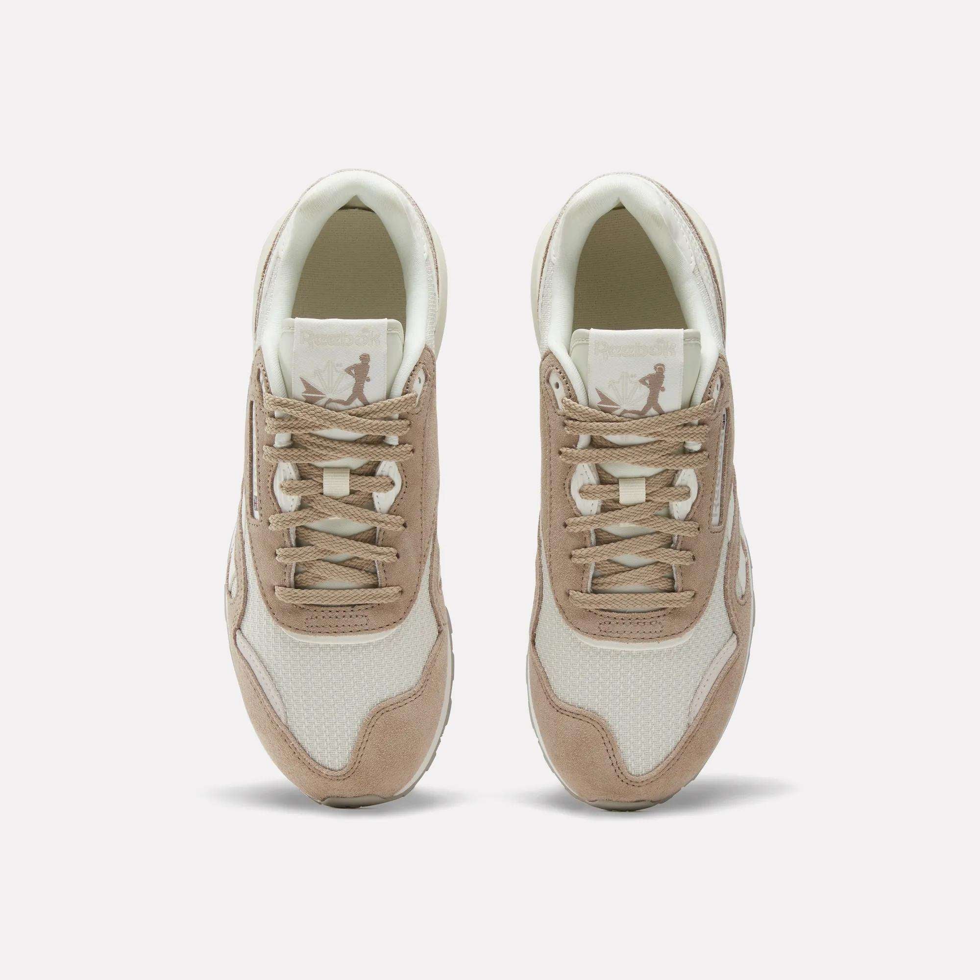 A pair of Women’s Classic Nylon 89 Shoes by Reebok in beige and white, seen from above, display laces, mesh texture, suede overlays, and a retro look with the Reebok logo on each tongue.