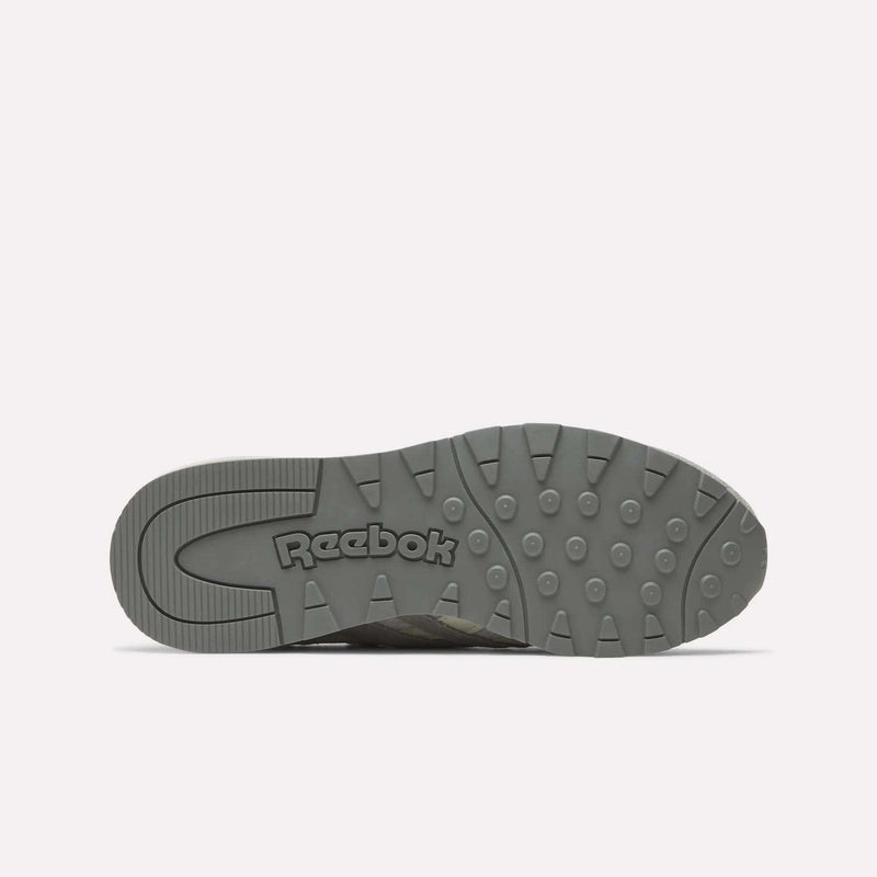 The Women's Classic Nylon 89 Shoes by Reebok are shown with the gray sole facing up, revealing the Reebok logo and a retro-inspired tread pattern with circular and angled grooves against a plain white background.