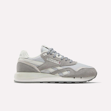 The Women's Classic Nylon 89 Shoes by Reebok are shown in light grey and white suede and mesh, side profile on a plain white background. Retro-inspired design features the iconic Reebok logo on the side panel.