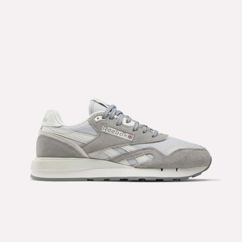 The Women's Classic Nylon 89 Shoes by Reebok are shown in light grey and white suede and mesh, side profile on a plain white background. Retro-inspired design features the iconic Reebok logo on the side panel.