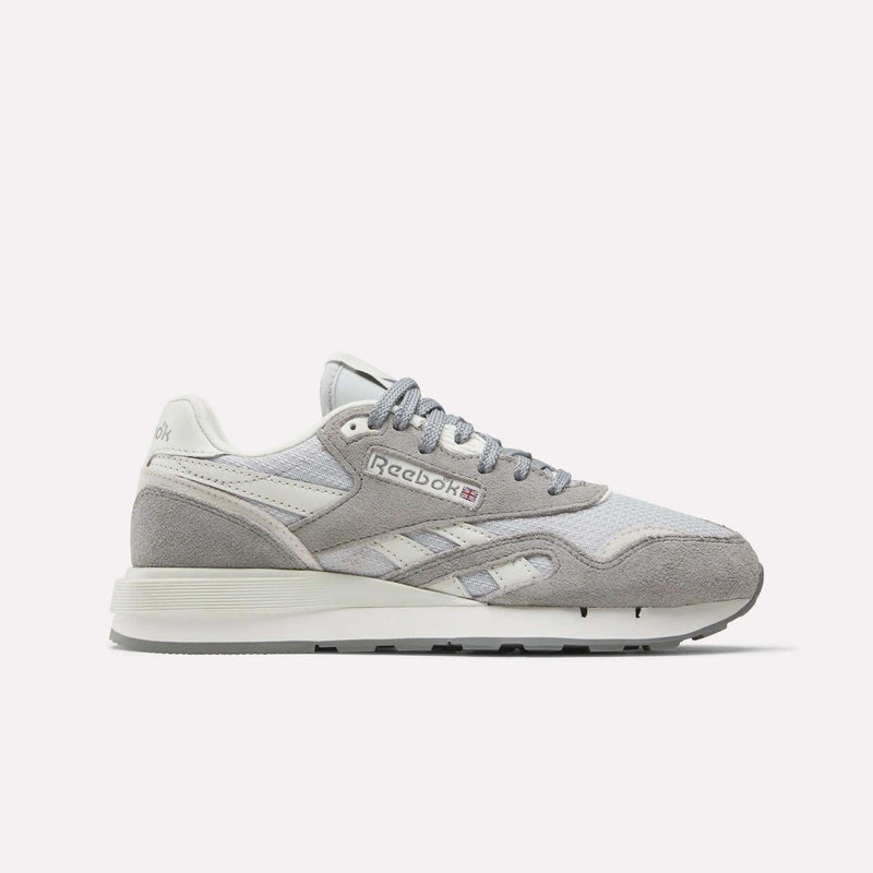 The Women's Classic Nylon 89 Shoes by Reebok are shown in light grey and white suede and mesh, side profile on a plain white background. Retro-inspired design features the iconic Reebok logo on the side panel.
