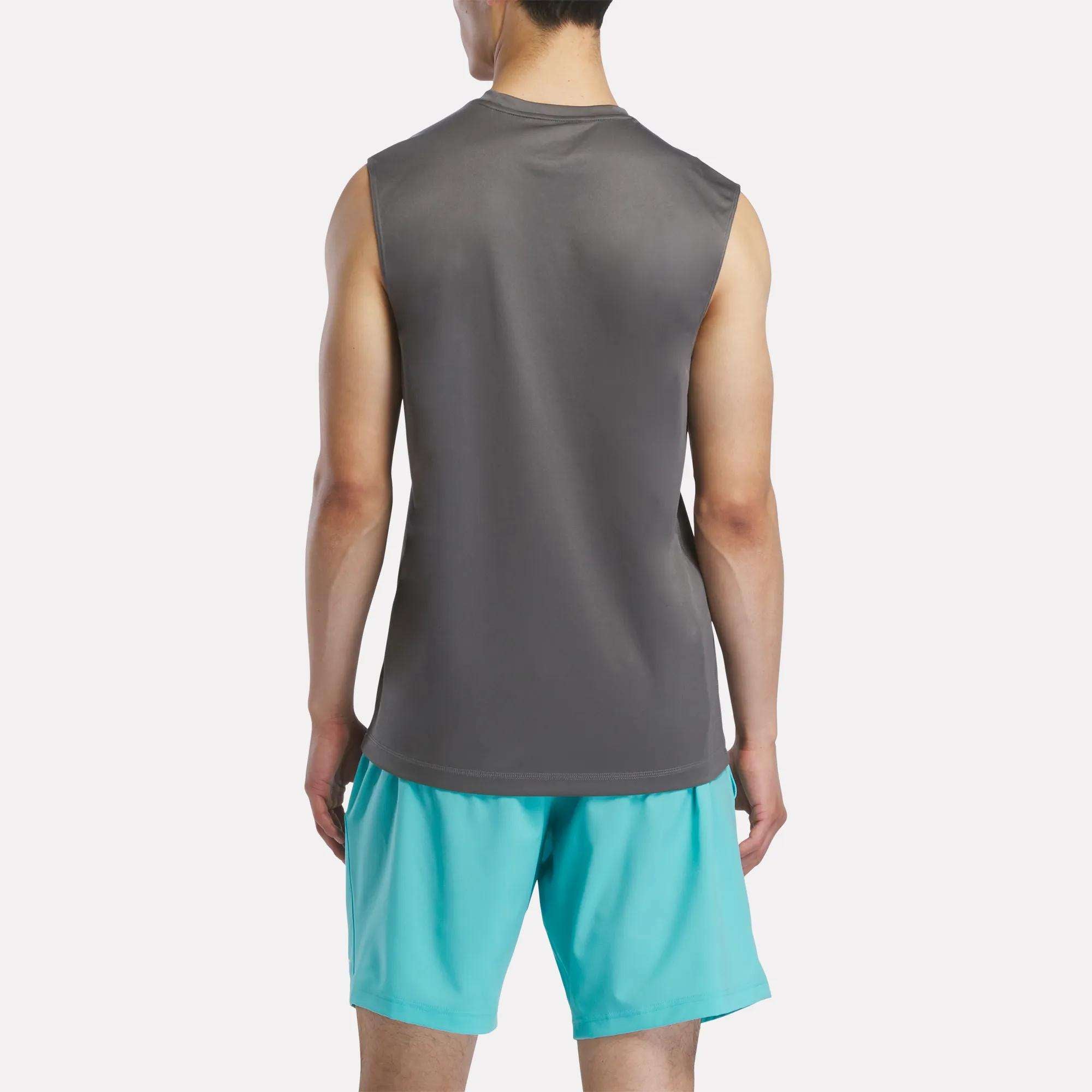 A man faces away, wearing a Reebok Men's Sleeveless Tech Training T-Shirt and light blue athletic shorts against a plain white background.