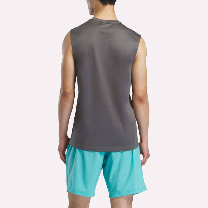 A man faces away, wearing a Reebok Men's Sleeveless Tech Training T-Shirt and light blue athletic shorts against a plain white background.