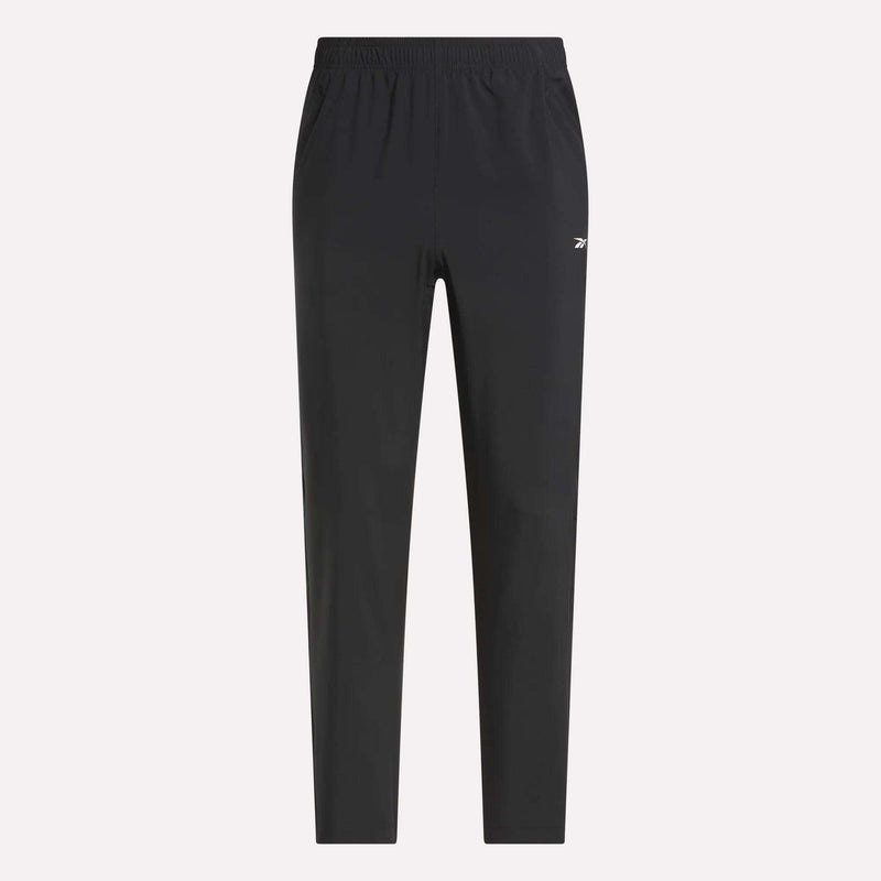Reebok Men's Woven Pants with elastic waistband and side pockets, featuring a small white logo on the left thigh. Lightweight polyester in black, shown on a light plain background for a sleek, sporty style.