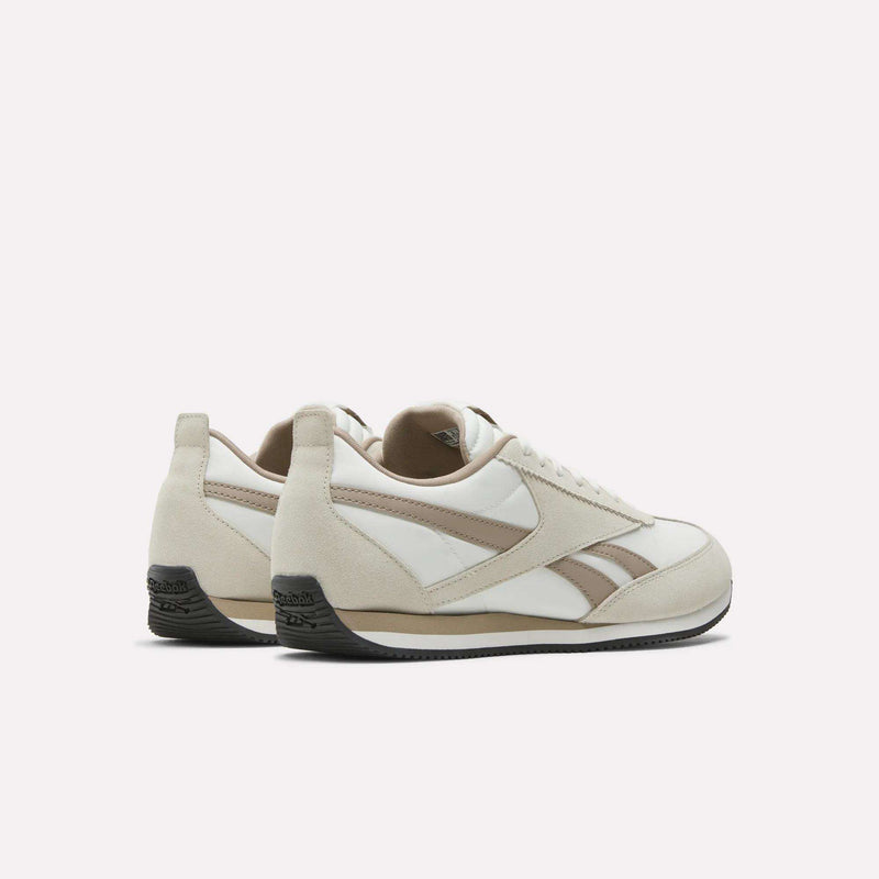 A pair of Reebok R100 Shoes in beige and white with tan accents, black soles, and a branded heel are shown from the back and side on a plain white background, capturing vintage '70s running style.