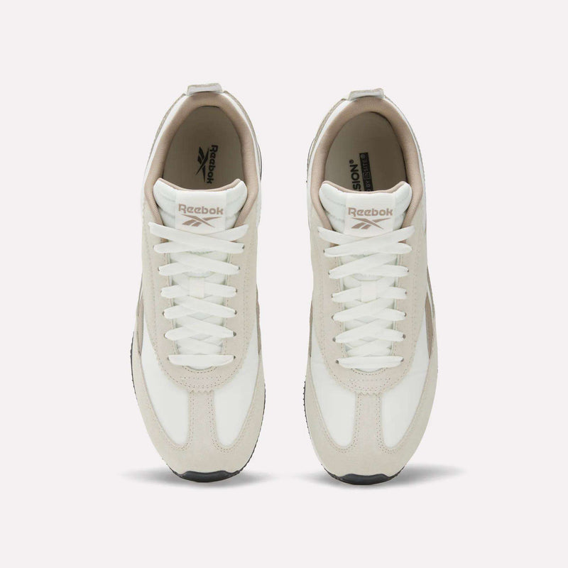 The Reebok R100 Shoes are pictured from above in beige and white with white laces. These low-profile sneakers feature the Reebok logo on the tongue and insole, showcasing a '70s-inspired running style against a plain white background.