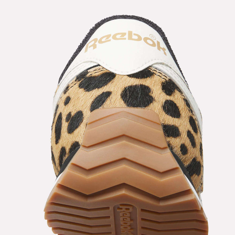 Close-up of the Reebok Women's Classic AZ Shoes, showing tan and black animal print pony hair on the heel, white leather accents, a light brown rubber sole, and the Reebok logo.