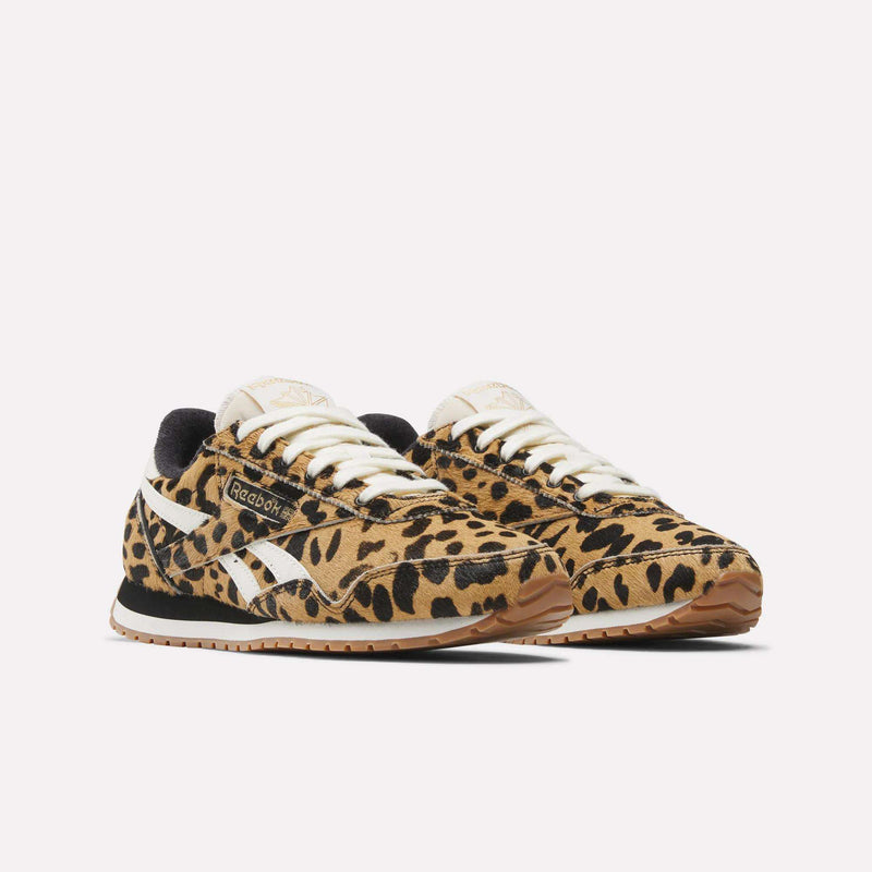 A pair of Reebok Women's Classic AZ Shoes with a bold leopard animal print, white side stripes and laces, black lining, and gum soles, shown against a plain white background.
