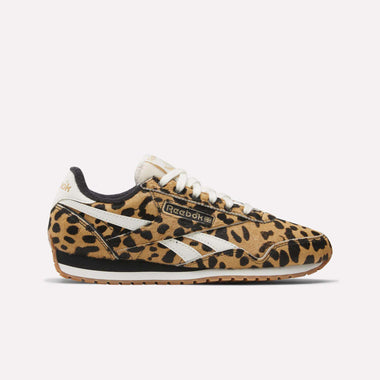 A side view of Reebok Women's Classic AZ Shoes features a bold leopard animal print, white Reebok stripes and laces, and a brown rubber sole, showcased against a plain light background.