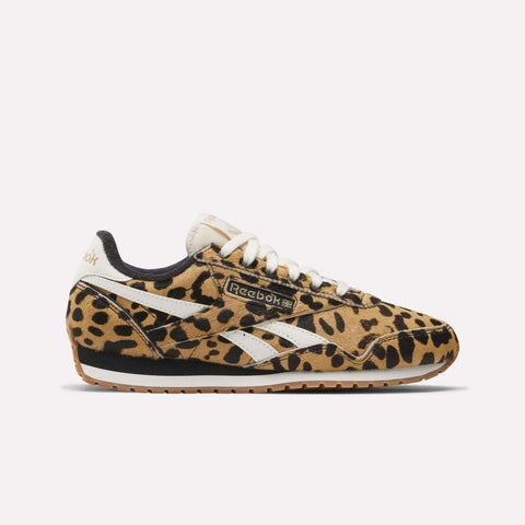 A side view of Reebok Women's Classic AZ Shoes features a bold leopard animal print, white Reebok stripes and laces, and a brown rubber sole, showcased against a plain light background.