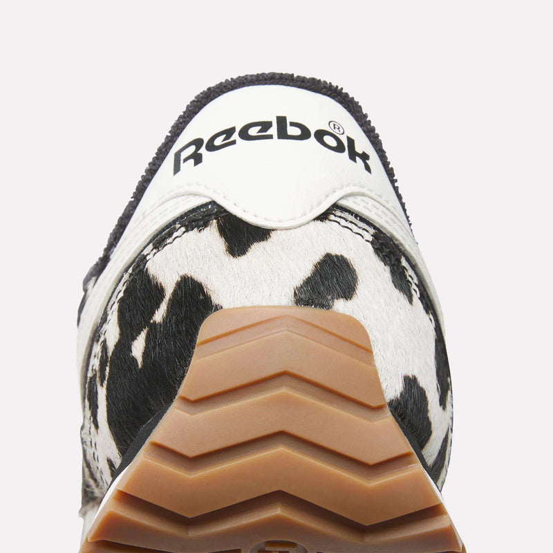 Close-up of the heel of Reebok Women's Classic AZ Shoes, featuring a white upper, black Reebok logo, animal print accents, and a gum rubber outsole.