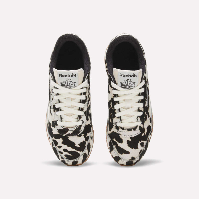 A top view of the Reebok Women's Classic AZ Shoes, featuring white laces and a striking black and white animal print pattern.