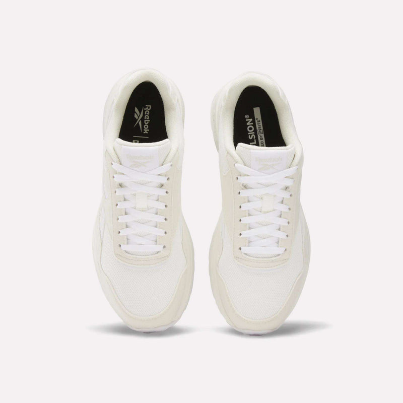 A pair of Reebok Women's GL1100 Shoes in white, seen from above, with white laces, mesh texture, and black insoles featuring Reebok branding on a plain white background—ideal for everyday wear.